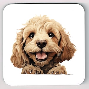 May include: A square coaster featuring a smiling, light brown Cockapoo dog illustration. The dog has dark eyes, a pink tongue, and its paws are visible. The artwork is detailed, with a focus on the dog's fur and expression.