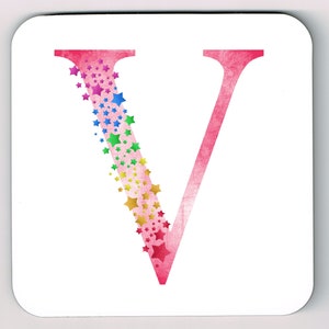 Op de afbeelding: Een witte vierkante onderzetter met een grote roze letter "V". De letter is versierd met een waterval van kleurrijke sterren in tinten rood, roze, geel, groen, blauw en paars. De onderzetter heeft afgeronde hoeken.