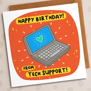 May include: A red and yellow birthday card featuring a cartoon laptop. The laptop has a green heart on the screen and the text "HAPPY BIRTHDAY!" and "FROM TECH SUPPORT!" on the card.