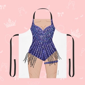 May include: A white apron with a black adjustable strap and a colorful sequined design of a woman's body. The design features a purple and blue sequined bodice with black fringe and a black garter belt.