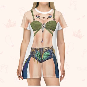 May include: A white t-shirt dress with a printed design of a woman wearing a green and blue costume with a butterfly motif. The costume includes a green bra with a jeweled embellishment, a blue skirt with a butterfly design, and a gold belt.