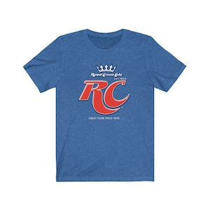 May include: A blue t-shirt with a red and white Royal Crown Cola logo. The logo features a crown, the letters RC, and the text "Great Taste Since 1905".