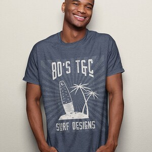 May include: A dark blue t-shirt with a white graphic design featuring a surfboard, palm trees, and the text "80's TGC Surf Designs".