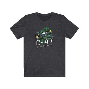 May include: Dark heather grey t-shirt with a green cartoon illustration of a Douglas C-47 Skytrain airplane. The airplane is surrounded by a green radar screen with the text "C-47" in white.