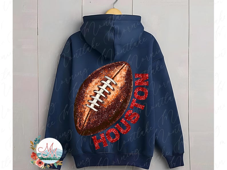 K&ouml;nnte beinhalten: Marineblauer Kapuzenpullover mit einem gro&szlig;en Football-Motiv und dem Wort "HOUSTON" in rotem Glitzer. Der Football ist braun mit wei&szlig;en Schn&uuml;rsenkeln. Der Kapuzenpullover hat eine Kapuze und einen Kordelzug.