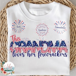 Puede incluir: Camiseta blanca con diseños de fuegos artificiales rojo, blanco y azul y el texto "This Grandma loves her firecrackers".