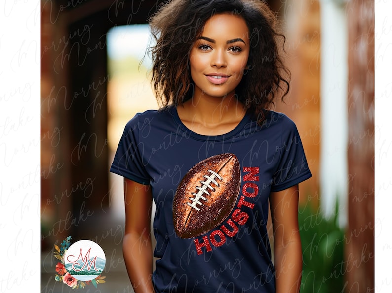 K&ouml;nnte beinhalten: Marineblaues T-Shirt mit einem Football-Motiv und dem Wort "HOUSTON" in rotem Glitzer. Der Football ist braun mit wei&szlig;en Schn&uuml;rsenkeln. Das T-Shirt hat einen Rundhalsausschnitt und kurze &Auml;rmel.