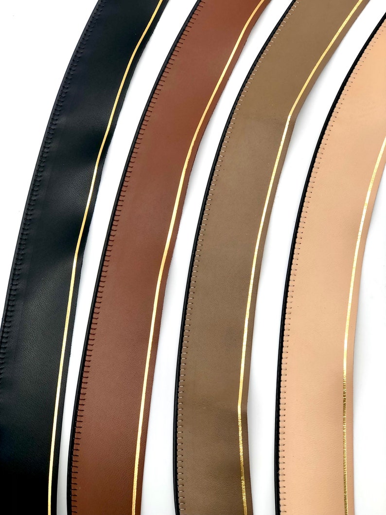 May include: Four different colours of leather trim with a gold stripe down the centre. The trim is stitched along the edges.