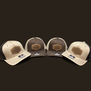 May include: Four brown and beige baseball caps with a brown leather patch that says "ERWIN" on each cap.