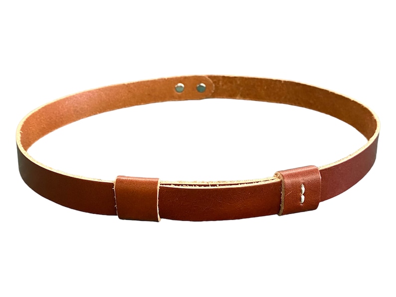 May include: A brown leather belt with a simple buckle design. The belt is adjustable and has a minimalist aesthetic.