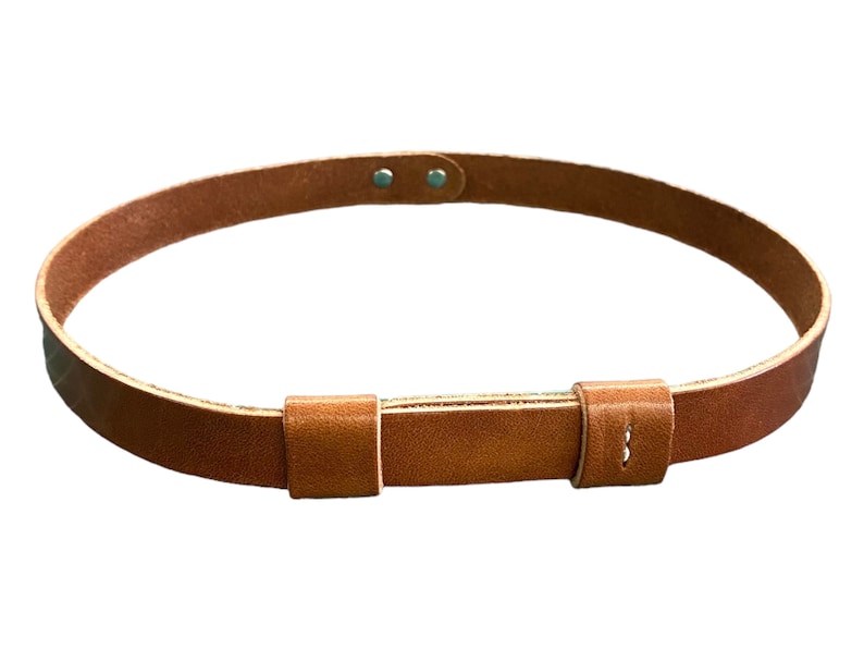 May include: A brown leather belt with a buckle and two metal rivets. The belt is made of a thick, durable leather and has a simple, classic design.