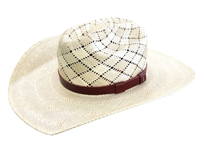 May include: A white straw cowboy hat with a brown leather band. The hat has a woven pattern and a wide brim.