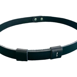 May include: A black leather belt with a simple buckle and two adjustable holes. The belt is made of a thick, durable leather and has a smooth finish.
