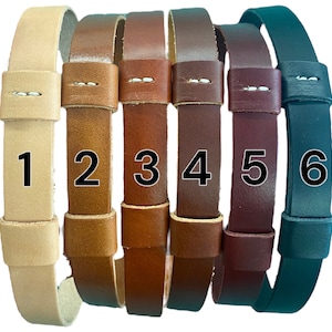 May include: Six leather straps in different colors, numbered 1 through 6. The straps are all the same width and have a simple design.