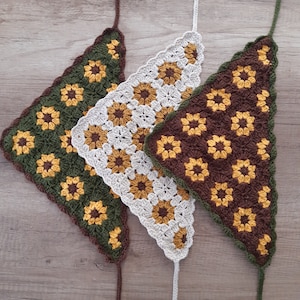 May include: Three crocheted triangle shawls in green, white, and brown with a sunflower pattern.