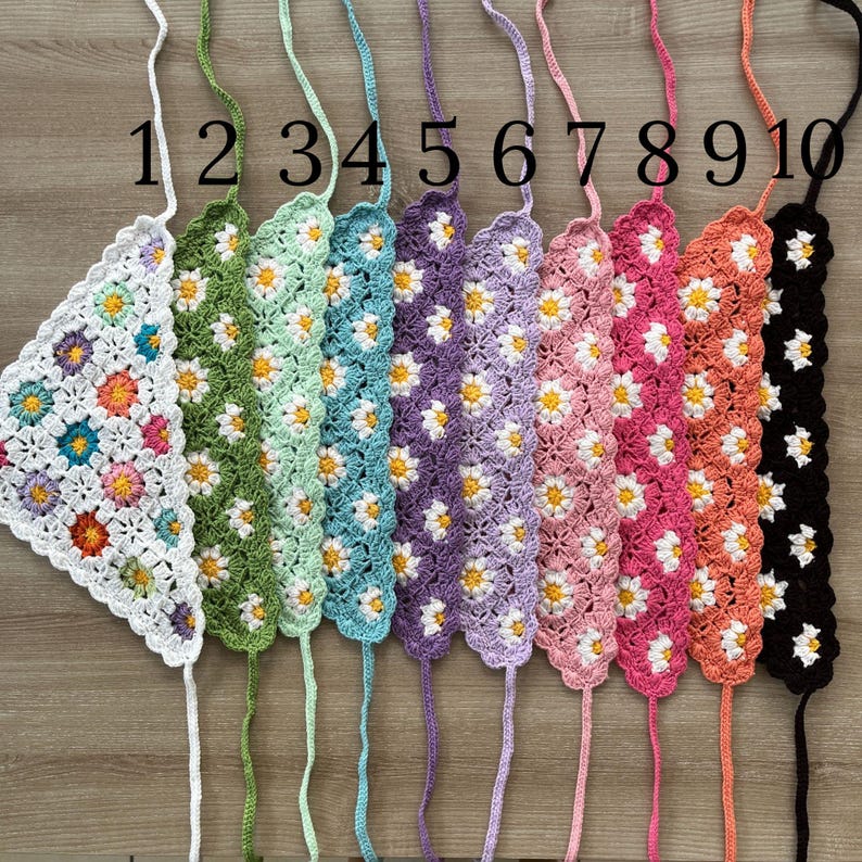 May include: Ten crocheted headbands with a daisy pattern in various colors, including green, light blue, purple, pink, and black. The headbands are numbered 1 through 10.