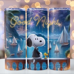 Puede incluir: Un vaso de acero inoxidable con una escena nocturna con Snoopy y Woodstock. El dise&ntilde;o incluye veleros, fuegos artificiales y las palabras "Good Night" en escritura dorada. El vaso es cil&iacute;ndrico y tiene tapa.