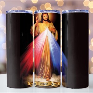 Puede incluir: Un vaso de acero inoxidable con un dise&ntilde;o envolvente que presenta una imagen religiosa de Jesucristo. La imagen tiene una combinaci&oacute;n de colores dorados, rojos y azules. El vaso tiene un fondo negro y una tapa transparente.