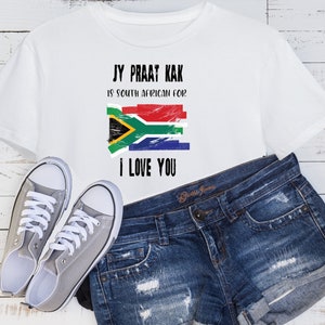 May include: White t-shirt with a distressed South African flag and the text "Jy Praat Kak is South African for I Love You."