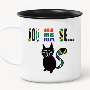 Pu&ograve; includere: Tazza in ceramica bianca con bordo e manico neri. La tazza presenta un gatto nero con una coda a bandiera sudafricana e il testo "Join the..." stampato su di essa.