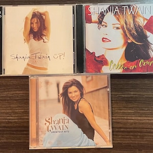 May include: A set of three ceramic mugs with a speckled, matte finish. The mugs are in shades of cream, light gray, and dark gray. Each mug has a simple, minimalist design and a rounded handle.