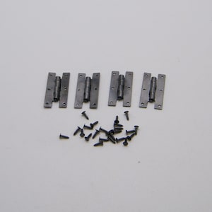 May include: Four silver hinges with small black screws. The hinges are all closed and are arranged in a row.