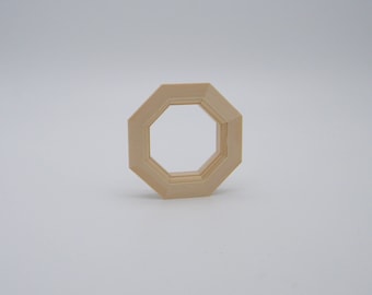 May include: A wooden octagon-shaped window frame with a beveled edge. The frame is light brown and has a smooth finish.