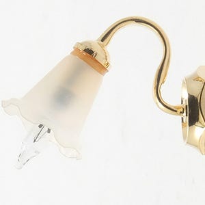 May include: A wall-mounted light fixture with a gold-colored, curved arm and a frosted glass shade. The shade is shaped like a flower with a scalloped edge. The fixture is designed to be mounted on a wall and has a small light bulb.