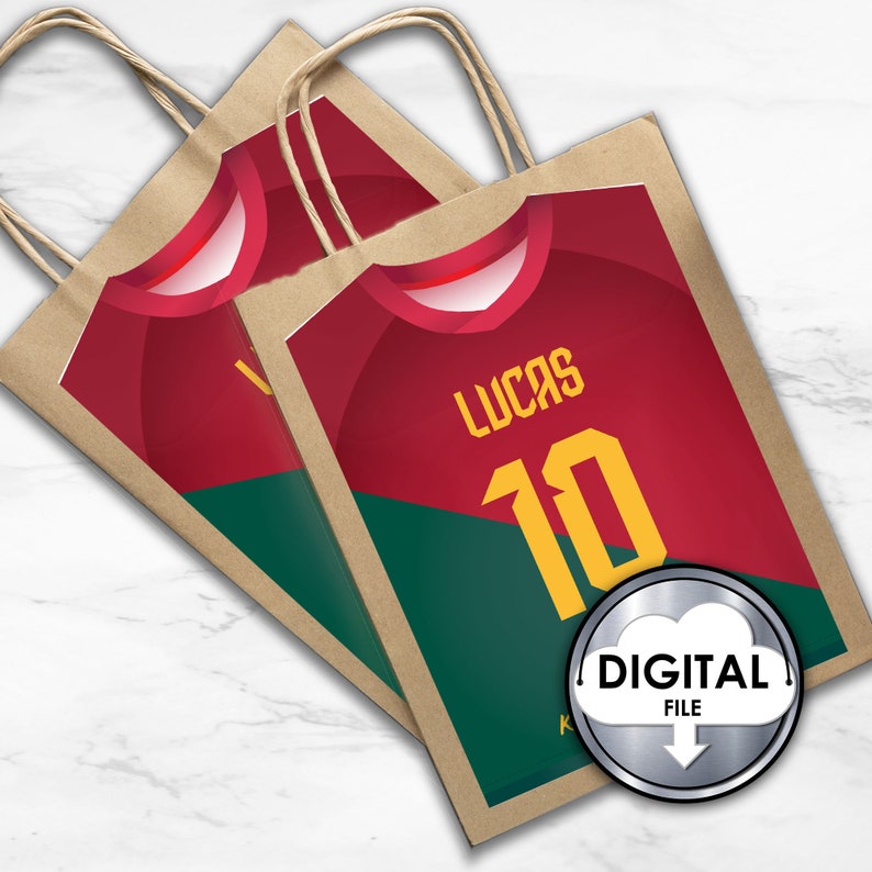 May include: Two brown paper gift bags with handles. The bags are decorated with a red and green soccer jersey design. The jersey has the name "Lucas" and the number "10" printed on it. The bags have a digital file label.