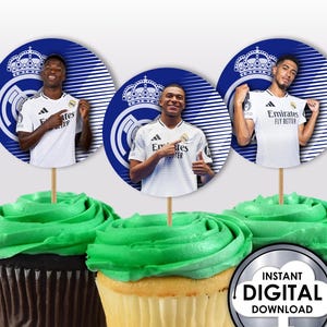 Könnte beinhalten: Drei runde Cupcake-Topper mit Fußballspielern, die weiße Trikots mit blauen und weißen Akzenten tragen. Die Topper haben einen blauen Hintergrund mit weißen Streifen und eine weiße Krone mit einem blauen Zentrum. Der Text auf dem Trikot lautet "Emirates Fly Better".