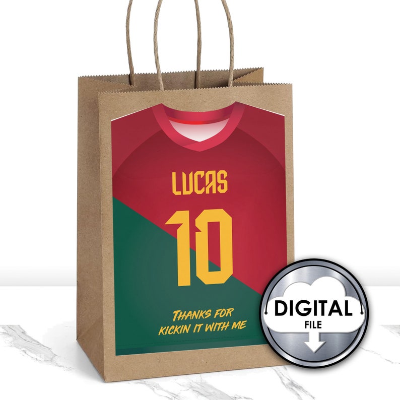 May include: A brown paper gift bag with a red and green soccer jersey design. The jersey has the name "Lucas" and the number "10" on it. The bag has the text "Thanks for kickin' it with me". A silver digital file icon is in the lower right corner.
