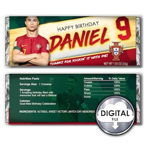 May include: A personalized chocolate bar wrapper featuring a soccer player in a red and green jersey with the number 7 on it. The wrapper has a green background with the text "HAPPY BIRTHDAY DANIEL 9 THANKS FOR KICKIN' IT WITH ME!" and a soccer ball graphic. The wrapper also includes the text "NET WT 1.55 OZ (43g)".