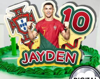 May include: A cake topper featuring a soccer player in a red and green jersey, a soccer ball, the number 10, and the name Jayden. The soccer player is Cristiano Ronaldo, a famous Portuguese soccer player.