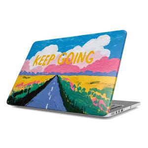 Può includere: Custodia per laptop con un dipinto colorato di una strada che si estende in lontananza sotto un cielo blu con nuvole. Le parole "KEEP GOING" sono in giallo. La custodia è su un laptop argentato.