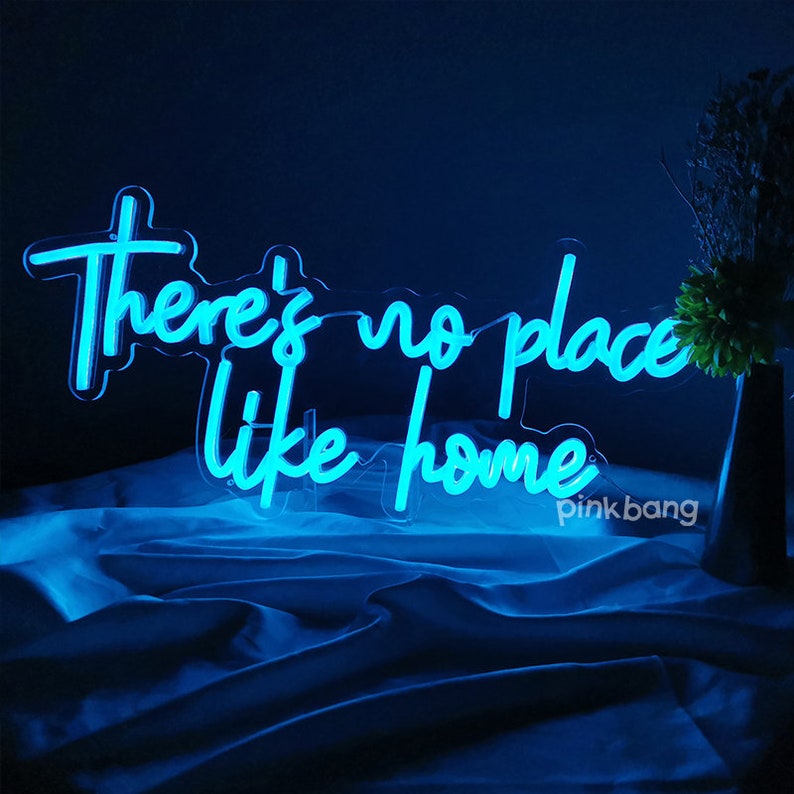 May include: Blue neon sign with the text "There's no place like home".