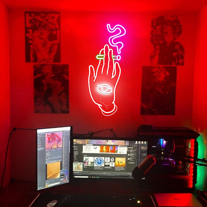 May include: A red room with a computer setup and neon signs on the wall. The neon signs are a hand with an eye and a question mark. The computer has three monitors, a keyboard, and a mouse.
