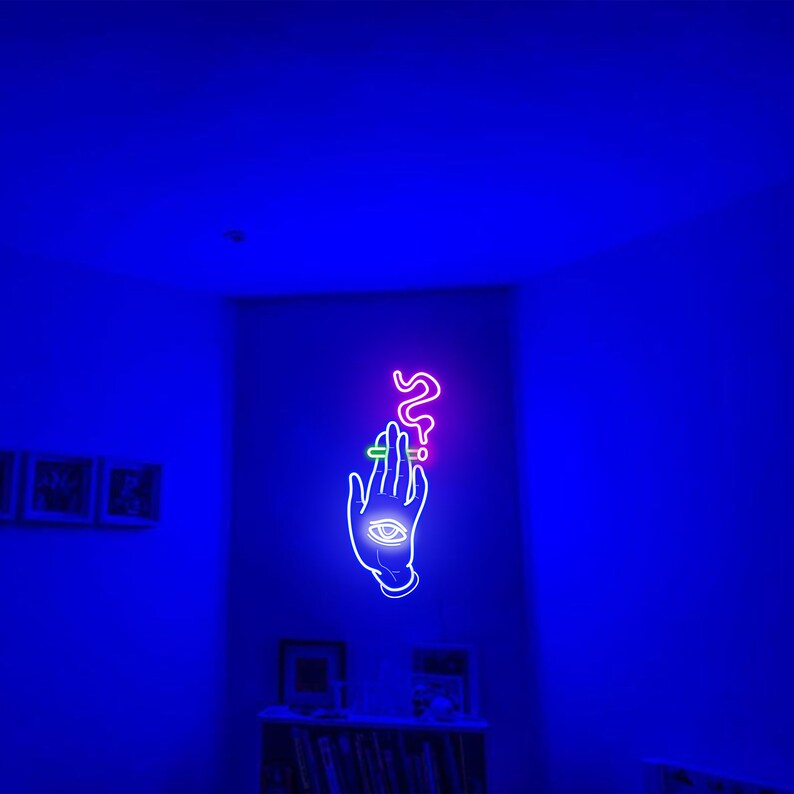 May include: A neon sign with a hand holding a cigarette with smoke rising from it. The hand has an eye in the palm. The sign is lit in pink, green, and blue.