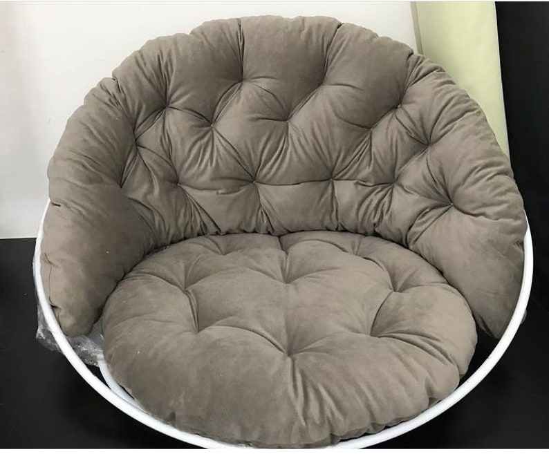May include: A round, gray, tufted cushion chair with a white metal frame. The chair is designed for indoor use and has a comfortable, padded seat.