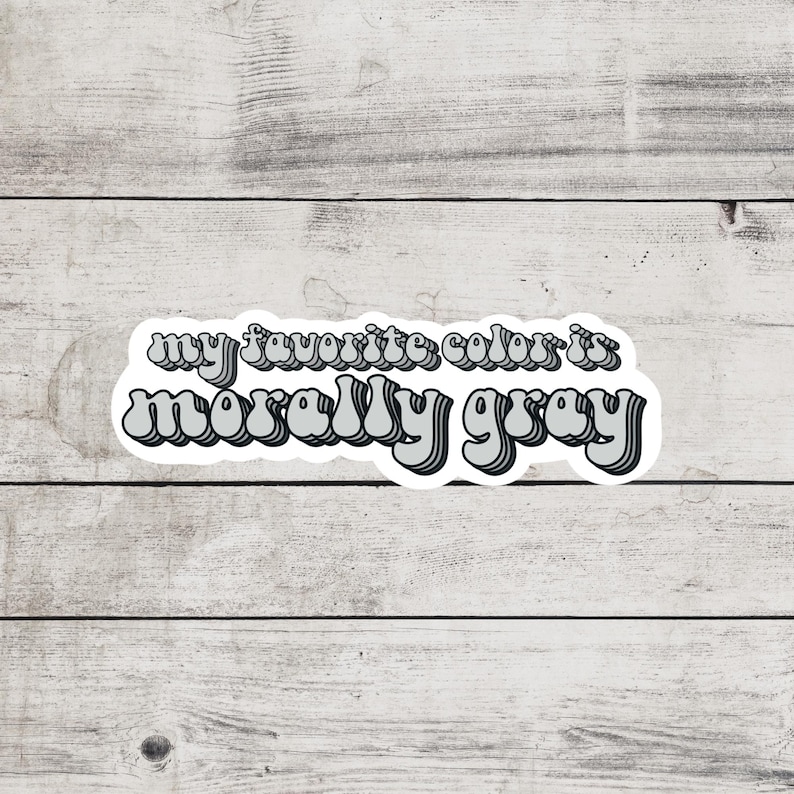 May include: A sticker with the text "my favorite color is morally gray" in a retro, layered, gray font.