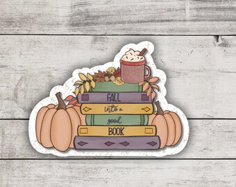 May include: A sticker with a stack of books, a cup of hot chocolate with whipped cream, and two pumpkins. The text on the sticker reads "Fall into a good book."