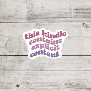 May include: A white sticker with the text "this kindle contains explicit content." in a pink and purple gradient.