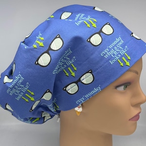 May include: Blue scrub cap with a repeating pattern of eyeglasses and the text "ever wonder what a cool CRNA looks like?" in white. The cap is designed for medical professionals and features a comfortable fit.