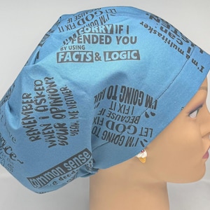 Könnte beinhalten: Eine hellblaue OP-Haube mit schwarzem Text. Die Haube enthält Sätze wie „Ich werde es reparieren“ und „Fakten & Logik“. Die Haube ist für den Einsatz im medizinischen Bereich konzipiert.