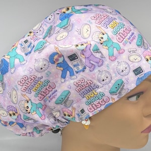 May include: A lavender scrub cap featuring a repeating pattern of cartoon medical staff in scrubs, disco balls, and medical equipment. The text reads "too much panic, not enough disco" and "STAT but make it funky" in colorful, playful lettering.