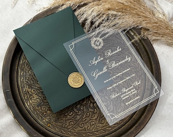 May include: An elegant wedding invitation suite featuring a dark green envelope sealed with a gold wax stamp. A transparent card displays the names "Aylin Rosales & Giselle Bermudez" and wedding details. The invitation rests on a decorative metal tray.