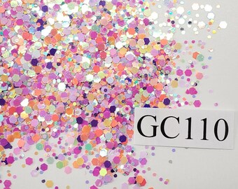 May include: A close-up of a variety of iridescent glitter in shades of pink, purple, orange, and white. The glitter is scattered on a white surface and labeled "GC110".