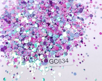 May include: A pile of iridescent glitter in shades of pink, purple, and blue. The glitter is in the shape of small circles. The glitter is labeled "GC634".