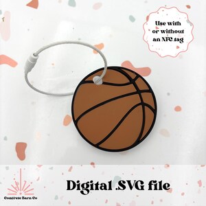 May include: A digital SVG file of a brown basketball with black lines. The basketball is attached to a silver metal loop. The text "Use with or without an NFC tag" is in a white circle.