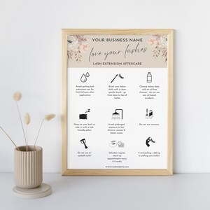 May include: A light brown framed poster with a floral design and the text "love your lashes" in a script font. The poster lists lash extension aftercare tips, including avoiding getting lashes wet for 24 hours, brushing lashes daily, sleeping on your back or side, and avoiding prolonged exposure to heat.