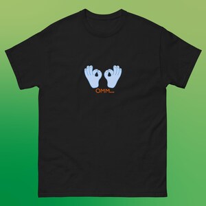 May include: Black t-shirt with a graphic of two blue hands making the "okay" sign with the text "OMM..." underneath.